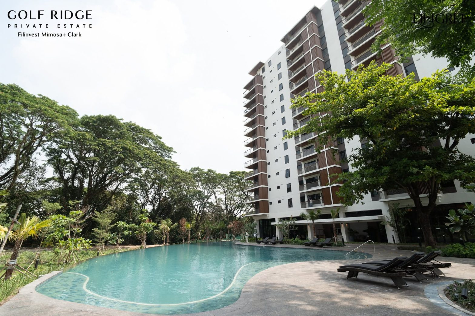 Golf Ridge Private Estate condominium building with a landscaped swimming pool and lush greenery.